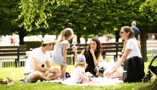 famille faisant un pique nique dans l'herbe